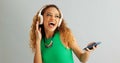 Happy woman, phone and listening with headphones to music and dancing on a gray studio background. Excited female person Royalty Free Stock Photo