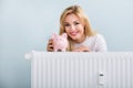 Happy Woman With Piggybank On Radiator