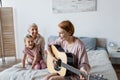 Happy woman playing acoustic guitar near Royalty Free Stock Photo