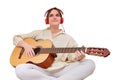 Happy woman playing acoustic guitar sitting at home in the living room Royalty Free Stock Photo