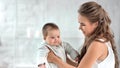 Happy woman playing with cute child smiling having fun together surrounded by natural light