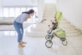 Happy woman plays with her baby in a stroller Royalty Free Stock Photo