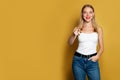 Happy woman pointing on bright yellow background. Positive emotion Royalty Free Stock Photo