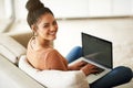 Happy woman in portrait, couch and laptop, typing for blog and freelance copywriter working from home. Female freelancer