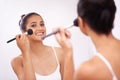 Happy woman, portrait and makeup brush in mirror for beauty, cosmetics or grooming in bathroom at home. Female person