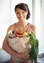 Happy woman, portrait and shopping bag with groceries, vegetables or fresh produce in kitchen at home. Female person Royalty Free Stock Photo