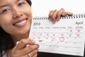 Happy woman, positive pregnancy test & calendar