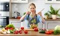 Happy woman preparing vegetable salad in kitchen Royalty Free Stock Photo