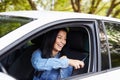 Happy woman pulling on seatbelt inside white car
