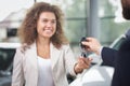 Happy woman purchasing auto, taking car keys.