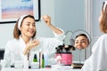 Happy woman putting facial serum with eyedropper on the face