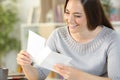 Happy woman putting letter on an envelope at home Royalty Free Stock Photo