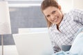 Happy woman in pyjama using laptop