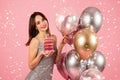 Happy woman with a radiant smile holding a stack of pink-frosted donuts with lit candles Royalty Free Stock Photo