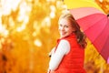 Happy woman with rainbow multicolored umbrella under rain in par