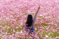 Happy woman raise hand and pointing finger up in beautiful pink cosmos flower garden Royalty Free Stock Photo