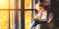 Happy woman reading book by autumn window