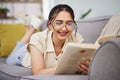 Happy woman, reading and book on sofa in home for story, novel and studying literature. Young student, gen z girl and Royalty Free Stock Photo