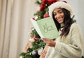 Happy woman reading Christmas card, letter or note in home living room in winter holiday celebration. Smile, festive or