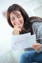 Happy woman reading letter at home in living room Royalty Free Stock Photo