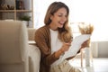 Happy woman reading letter near sofa at home Royalty Free Stock Photo