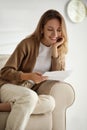 Happy woman reading letter on sofa at home Royalty Free Stock Photo