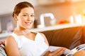 Happy woman reading a magazine sitting on a sofa Royalty Free Stock Photo