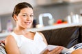 Happy woman reading a magazine sitting on a sofa Royalty Free Stock Photo