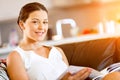 Happy woman reading a magazine sitting on a sofa Royalty Free Stock Photo