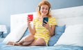 Happy woman reading news on smartphone at home, relaxation. Morning relax. Enjoying weekend morning Royalty Free Stock Photo