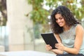 Happy woman reading online content in a tablet or ebook