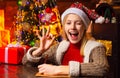 Happy woman is ready for Christmas eve. New Year mood. Attractive woman in a Christmas room. Give a wink. Crazy comical Royalty Free Stock Photo