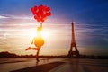 Happy woman with red balloons jumping near Eiffel tower in Paris Royalty Free Stock Photo