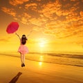 Happy Woman red holding umbrella and Jumping in Sea Sunset Royalty Free Stock Photo