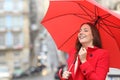 Happy woman in red keeping warm in a rainy winter day