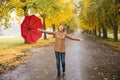 Happy woman with red umbrella walking at the rain in beautiful autumn park Royalty Free Stock Photo