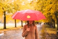 Happy woman with red umbrella walking at the rain in beautiful autumn park Royalty Free Stock Photo