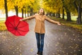 Happy woman with red umbrella walking at the rain in beautiful autumn park. Royalty Free Stock Photo
