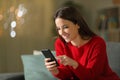 Happy woman in red using mobile phone in the night