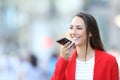 Happy woman in red using voice recognition on phone