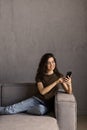 Happy woman relaxing on comfortable sofa, enjoying web surfing information in internet or using mobile software application,