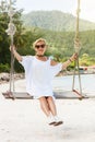 Happy woman relaxing with hanging swing on tropical beach Royalty Free Stock Photo