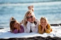 Happy woman relaxing with her two daughters outdoor on the beach, lying, talking and smiling. Mother`s day. Children`s day Royalty Free Stock Photo