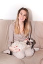 Happy woman relaxing at home on sofa and embracing cat pet in couch friendship love Royalty Free Stock Photo