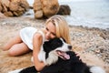 Happy woman relaxing and hugging her dog on the beach Royalty Free Stock Photo