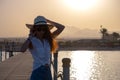 Happy woman relaxing outdoors on hotel deck on sea shore enjoying warm tropic evening. Summer vacations and travelling concept Royalty Free Stock Photo