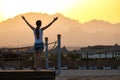 Happy woman relaxing outdoors on hotel deck on sea shore enjoying warm tropic evening. Summer vacations and travelling concept Royalty Free Stock Photo