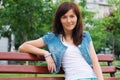 Happy woman relaxing in the park. Beautiful young woman outdoors. Enjoy nature. Healthy smiling girl on green grass background. Royalty Free Stock Photo