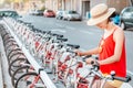 Woman renting bicycle at public urban cycle transport station