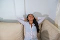 Happy woman resting comfortably sitting on a couch in the living room at home Royalty Free Stock Photo